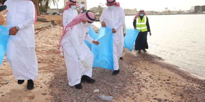 صورة لجنة تقصي من أمانة تبوك بعد مقطع عامل نظافة يلقي المخلفات على شاطئ حقل